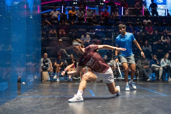 Paul Coll Superman limited edition squash shirt – XTPro performance fabric in red on court retrieving a ball