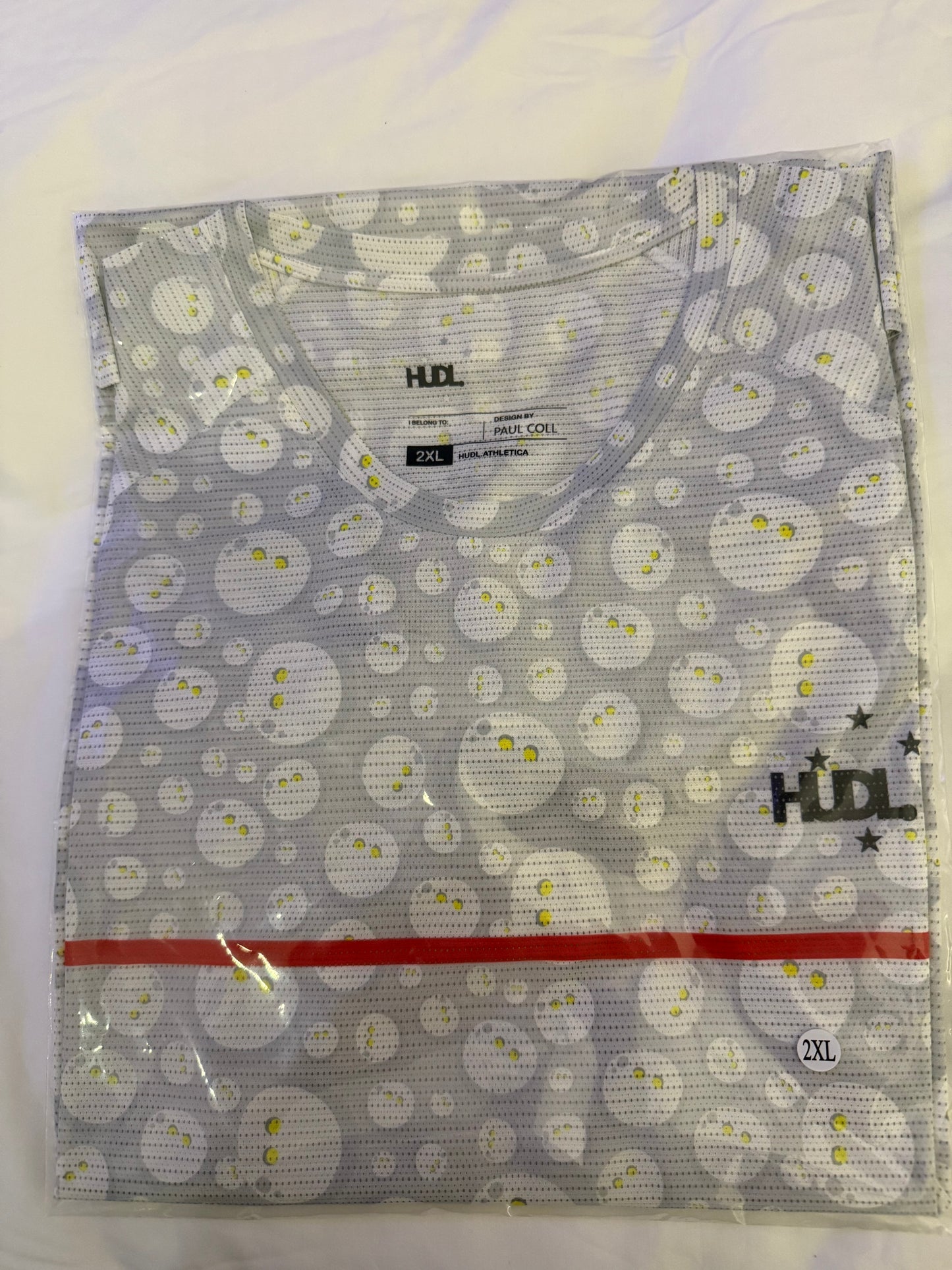 HUDL Rally in Motion limited edition squash tee – XTPro silver infused performance fabric, unique graphic design in grey with white  squash balls 