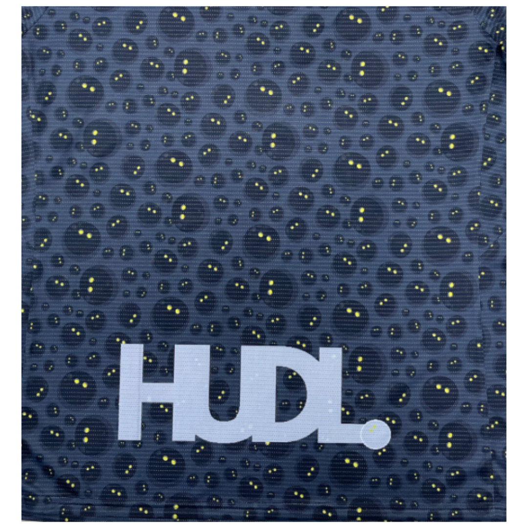 Close up of HUDL Rally in Motion limited edition squash tee – XTPro silver infused performance fabric, unique graphic design in grey  with white squash balls 